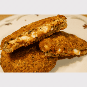 Fritura de pollo rellena de queso y ingredientes crujientes.